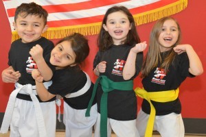 white, yellow and green belt students in children's karate TaeKwonDo martial arts class